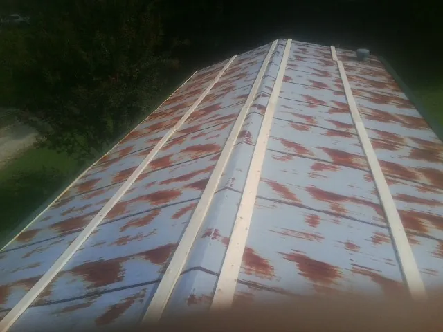 Rusted metal roof panels with new wood purlins before replacement — Storm Damage Roof Repair in Pond Creek by Roofing Brothers