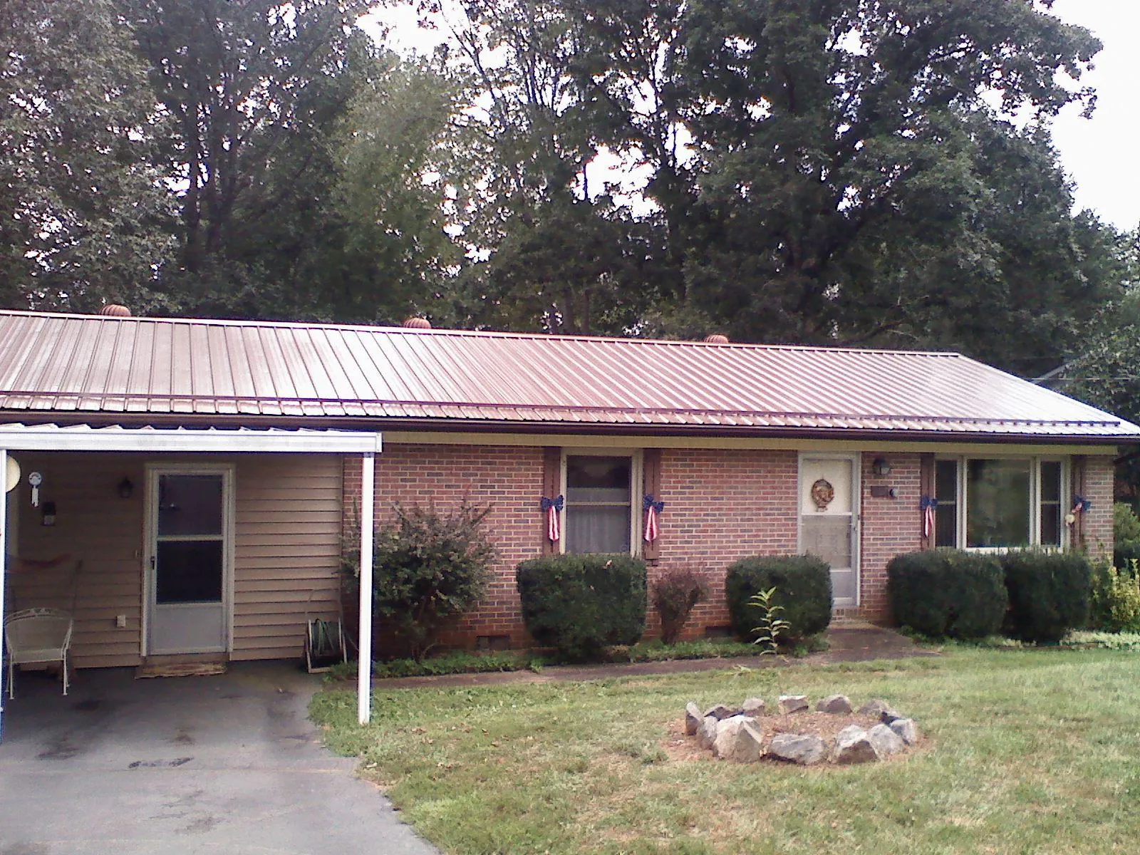 Bronze metal roof and carport on a brick ranch home — Roof Repair work by our crew in Pond Creek